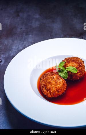 Eine vertikale Nahaufnahme von zwei Fleischbällchen auf der weißen Platte Stockfoto