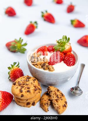 Creme-Dessert mit Erdbeerfrucht in einer Schüssel auf blauem Hintergrund Stockfoto