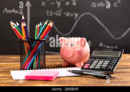 Sparschwein mit Taschenrechner und Bleistiften Stockfoto