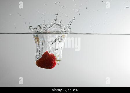 Die Erdbeere fiel ins Wasser Stockfoto