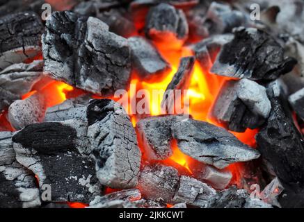 Eine Nahaufnahme von brennenden Grillkohlen in knallroter Farbe Stockfoto