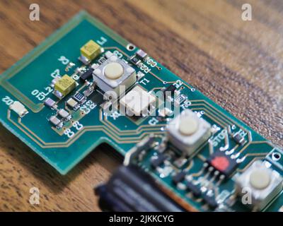 Ein grünes elektronisches Modul auf einem Holztisch Stockfoto