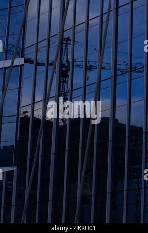 Das Gebäudeglas spiegelt die Stadt bei Sonnenuntergang wider Stockfoto