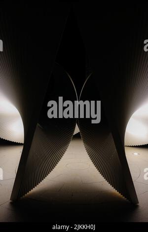 Eine vertikale Aufnahme futuristischer parametrischer Architektur in einem dunklen Raum mit weniger Licht Stockfoto