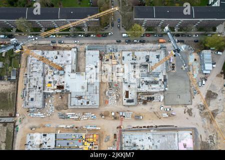 Luftaufnahme einer Baustelle mit Kränen vor einer belebten Straße Stockfoto