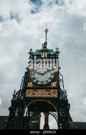 Eine vertikale Low-Angle-Aufnahme der Eastgate-Uhr gegen einen bewölkten Himmel in Chester, England Stockfoto