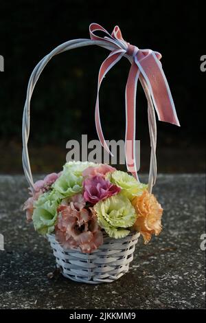 Bouquet von saisonalen Blumen in einem Korb mit Band Stockfoto
