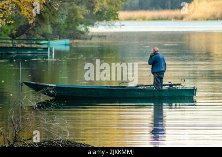 Bevec, Serbien - Oktober 30. 2021: Sportfischer in einem Boot auf einem künstlichen See in der Nähe von Novi Sad. Stockfoto