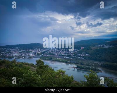 Ein Blick aus der Vogelperspektive auf einen Fluss, der an einem düsteren Tag in Deutschland durch Bingen am Rhein fließt Stockfoto