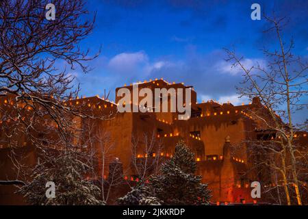 Zur Weihnachtszeit leuchten dekorative Luminarien die Dächer und Wände des im Pueblo-Stil gehaltenen Loretto Inn auf. Santa Fe New Mexico Stockfoto