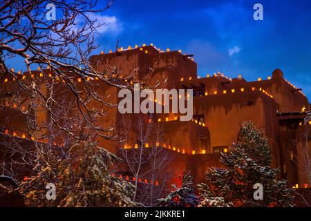 Zur Weihnachtszeit leuchten dekorative Luminarien die Dächer und Wände des im Pueblo-Stil gehaltenen Loretto Inn auf. Santa Fe New Mexico Stockfoto