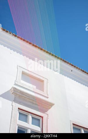 Ein weiß getünchtes Gebäude in Lissabon Portugal mit einem Kunstwerk aus bunten Fäden Stockfoto