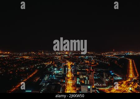 Eine lange Luftaufnahme der beleuchteten Stadt bei Nacht Stockfoto