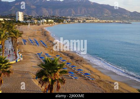 Während des Sonnenaufgangs praktiziert eine Gruppe von Menschen Yoga am Strand in Altea, Alicante, Spanien Stockfoto