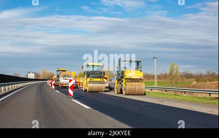 Straßenarbeiten auf der Autobahn. Asphaltwalzen und andere Ausrüstung Stockfoto