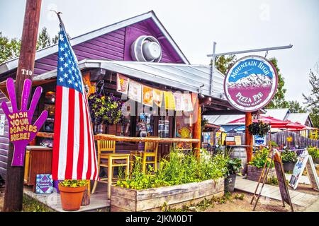 2022 06 26  Talkeetna Alaska USA - Restaurant Mountain High Pizza Pie in der Kabine mit Puple Siding waschen Sie Ihre Hände hier Zeichen und amerikanische Flagge sowie Stockfoto