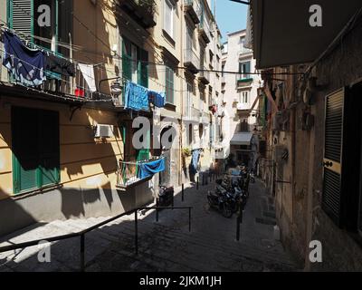 Typische Straße im Zentrum von Neapel, steil und eng mit Wäsche hängen aus, um zu trocknen, und viele Roller, Neapel, Kampanien, Italien Stockfoto