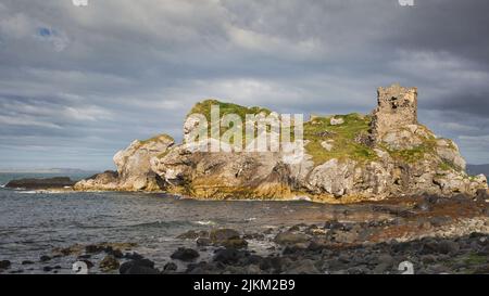 Die Überreste einer kleinen Burg auf einem Felsvorsprung der Atlantikküste in Nordirland Stockfoto