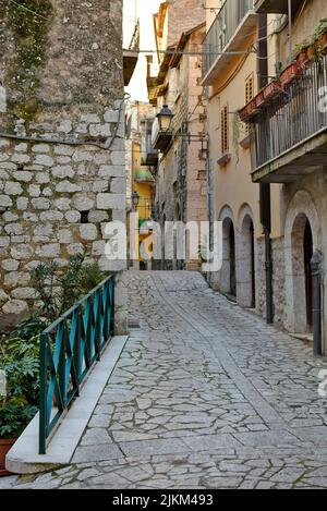 Eine vertikale Aufnahme einer schmalen Straße zwischen alten Gebäuden in einem Dorf in der Provinz Benevento in Italien. Stockfoto