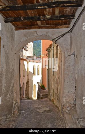 Der gewölbte Eingang und eine schmale Straße mit alten Häusern in Rivello, Italien Stockfoto