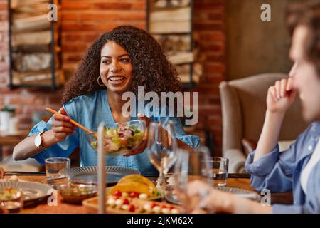 Porträt der schönen schwarzen Frau genießen Dinner-Party mit Freunden in gemütlicher Umgebung Stockfoto