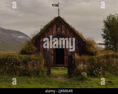 Eine kleine Holzhütte auf dem Feld am Fuße der Berge in Island Stockfoto