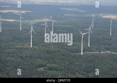 Moeckmühl, Württemberg, Deutschland, 11. Juli 2022 Windkraftanlagen in einem grünen Wald von einem kleinen Flugzeug aus gesehen Stockfoto