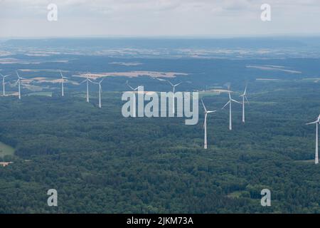 Moeckmühl, Württemberg, Deutschland, 11. Juli 2022 Windkraftanlagen in einem grünen Wald von einem kleinen Flugzeug aus gesehen Stockfoto