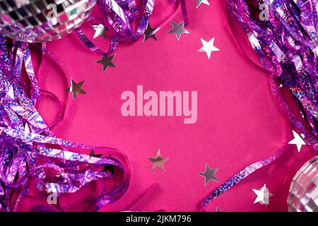 Konfetti und Mini-Disco-Kugeln auf einem Weihnachts- oder Neujahrsparty-Hintergrund. Stockfoto