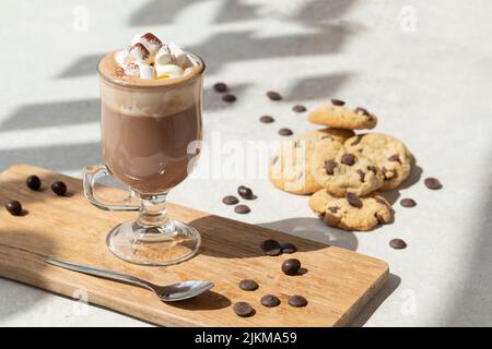 Eine Nahaufnahme einer heißen Schokolade in einem Glas in der Nähe der Kekse Stockfoto