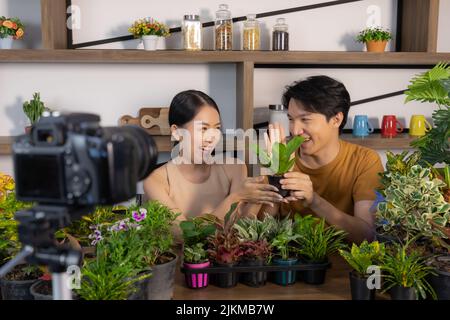 Ein südostasiatisches Paar, das sich um Pflanzen kümmert und lächelt Stockfoto