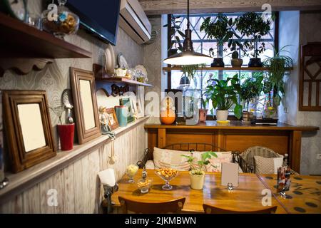 Interieur des Restaurants im Landhausstil. Gemütliches Restaurant im französischen Stil mit leeren Rahmen für Gemälde und Fotos an den Wänden Stockfoto