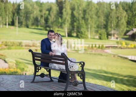 Eine wunderschöne Aussicht auf liebevolle Brautjungvermählte, die ihre Zeit im Park privat genießen Stockfoto
