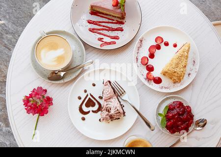 Auswahl an natürlichen veganen, geschichteten Desserts, Stück Kuchen mit frischen Früchten und Beeren. Feier, Auswahl an Kuchen auf der Terrasse. Draufsicht Stockfoto