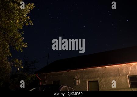 Eine Aufnahme eines sternenklaren Nachthimmels über einem Haus Stockfoto