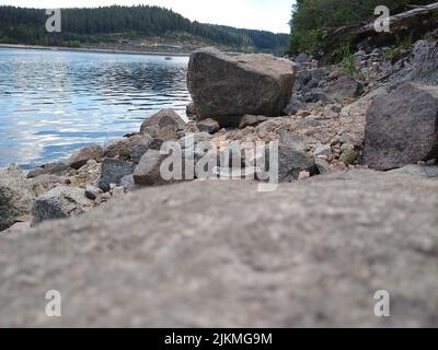Eine malerische Aussicht auf einen See gegen Berge mit grünen Bäumen unter dem blau bewölkten Himmel bedeckt Stockfoto