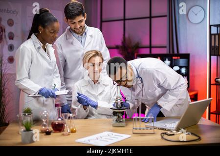 Ansicht des modernen universitären Forschungslabors mit einem multirassischen Team junger Wissenschaftler, das Experimente an Laborgeräten durchführt. Stockfoto