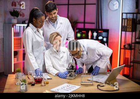 Ansicht des modernen universitären Forschungslabors mit einem multirassischen Team junger Wissenschaftler, das Experimente an Laborgeräten durchführt. Stockfoto