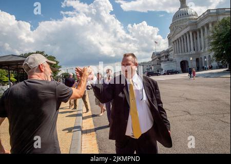 Washington, Vereinigte Staaten. 02. August 2022. Der US-Senator Jon Tester (Demokrat von Montana), rechts, wird von dem Komiker und Veteranen-Aktivisten Jon Stewart begrüßt, links, nachdem er sich mit Veteranen vor der erwarteten endgültigen Verabschiedung eines Gesetzes für Veteranen mit toxischen Expositions-Erkrankungen vor dem US-Kapitol in Washington, DC, am Dienstag, den 2. August, 2022. Kredit: Rod Lampey/CNP/dpa/Alamy Live Nachrichten Stockfoto