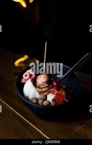 Eisdessert mit süßem Belag, gebranntem Moormarmelauch, gefärbtem Müsli, Schokoladengetreide, Panda-förmigen Gummitüssen, Reis Stockfoto