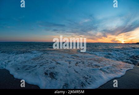 Ogmore-by-Sea Beach Sunset, Ogmore-by-Sea, Val of Glamorgan - schaumides Wasser, während die Flut hereinkommt Stockfoto