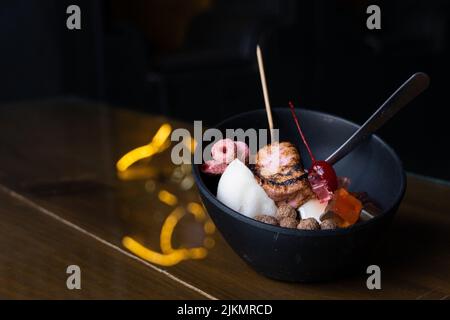 Eisdessert mit süßem Belag, gebranntem Moormarmelauch, gefärbtem Müsli, Schokoladengetreide, Panda-förmigen Gummitüssen, Reis Stockfoto