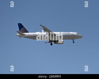 Ein United Airlines Airbus A320 im Flug mit blauem Himmel Stockfoto