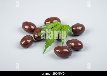 Schokoladen-Bonbons mit thc-Extrakt, süße Haselnüsse in Schokolade mit Marihuana. Stockfoto