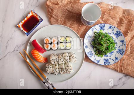Set aus Sushi, Maki und Wakame auf einem Marmortisch. Draufsicht mit Kopierbereich Stockfoto