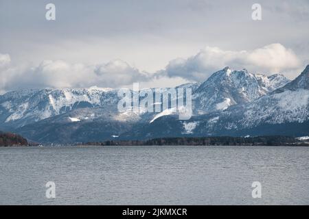 Eine malerische Aussicht auf den Wolfgangsee in Österreich umgeben von Bergen auf einem bewölkten Himmel Hintergrund Stockfoto