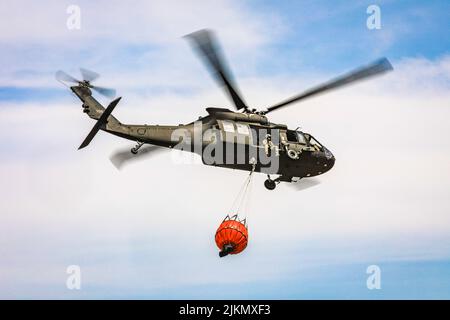 Oklahoma, USA. 16.. Juli 2022. Eine Oklahoma Army National Guard UH-60 Black Hawk fliegt über das Feuer von 702 in Blaine County, Oklahoma, nachdem sie am 16. Juli 2022 mehr als 600 Gallonen Wasser auf das Feuer geworfen hat. Die Oklahoma National Guard unterstützt die Oklahoma Forestry Services und die örtlichen Feuerwehren aus der Luft mit einem UH-60 Black Hawk und einem LUH-72 Lakota. Quelle: Oklahoma National Guard/ZUMA Press Wire Service/ZUMAPRESS.com/Alamy Live News Stockfoto