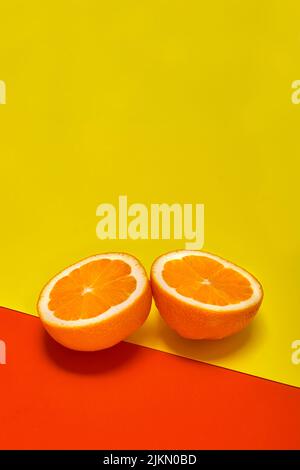 Zwei orangefarbene Scheiben auf gelbem und rotem Hintergrund Stockfoto