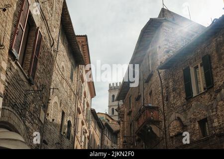 Die alten Backsteingebäude mit Fenstern gegen einen bewölkten Himmel in Assisi, Italien Stockfoto
