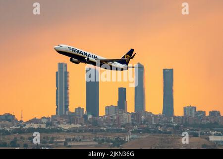 Madrid, Spanien. 02. August 2022. Ein Ryanair-Flugzeug, das während eines Sommersturms bei Sonnenuntergang vom Flughafen Adolfo Suarez Madrid Barajas abfliegt, kommt an den Wolkenkratzern des Geschäftsviertels Four Towers vorbei. Regen und Hagel haben die Stadt Madrid während eines Sommersturms erreicht, begleitet von hohen Temperaturen während einer Hitzewelle, bei der in einigen Gebieten der Gemeinde Madrid tagsüber 40 Grad Celsius überschritten wurden. Quelle: Marcos del Mazo/Alamy Live News Stockfoto